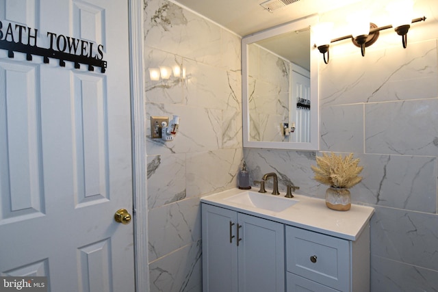 bathroom with vanity and tile walls