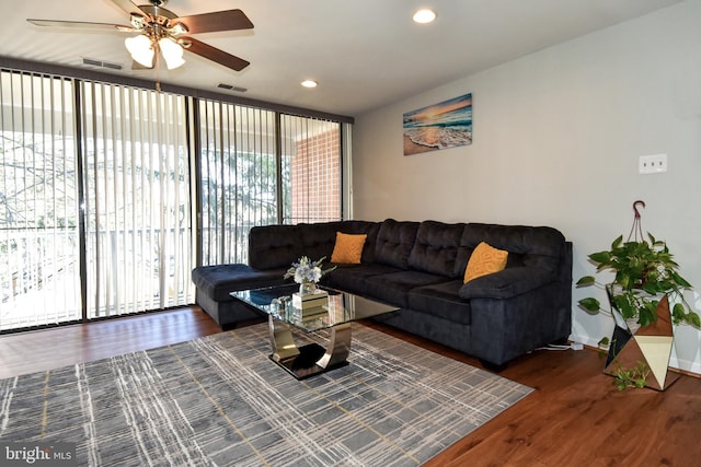 living room with dark hardwood / wood-style flooring and ceiling fan