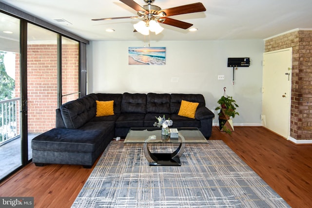 living room with hardwood / wood-style floors, a wall of windows, and ceiling fan