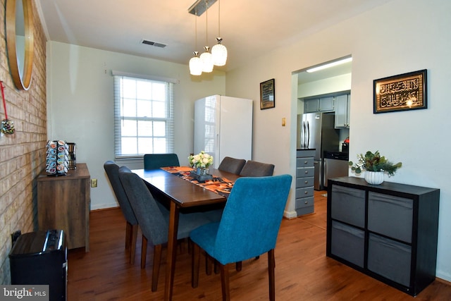 dining space with hardwood / wood-style floors and a chandelier