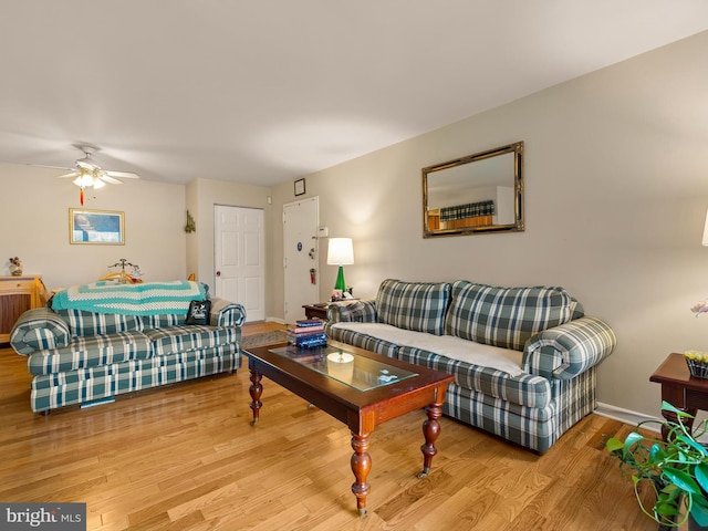 living room with light hardwood / wood-style flooring and ceiling fan