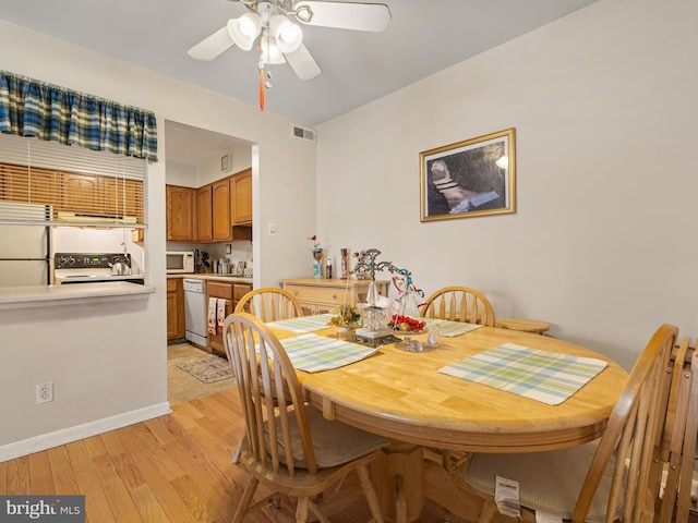 dining space with ceiling fan and light hardwood / wood-style floors