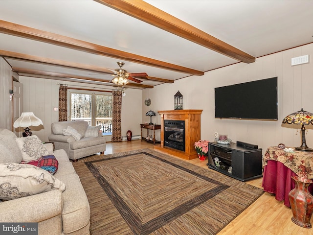 living room with beamed ceiling, ceiling fan, and wood-type flooring