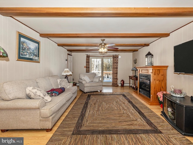 living room featuring ceiling fan, light hardwood / wood-style flooring, and beamed ceiling