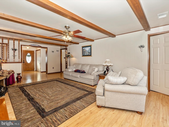 living room with beamed ceiling, ceiling fan, and light wood-type flooring