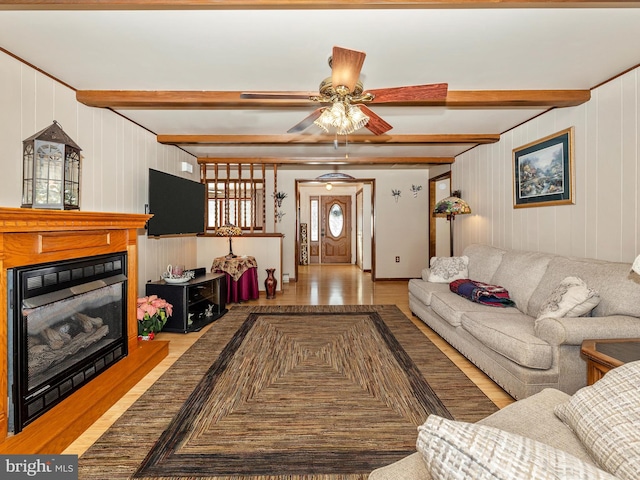 living room with beam ceiling, light hardwood / wood-style flooring, ceiling fan, and wood walls