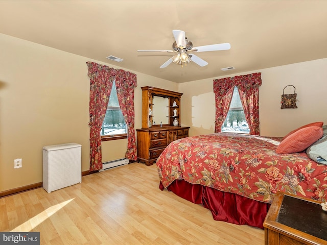 bedroom with multiple windows, ceiling fan, light wood-type flooring, and a baseboard heating unit