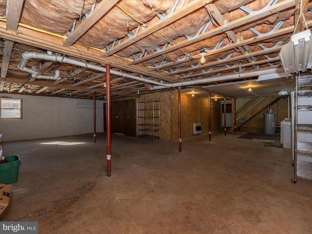 basement with heating unit, water heater, and washer / dryer