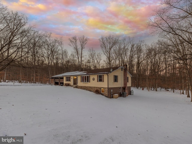 snow covered back of property with cooling unit