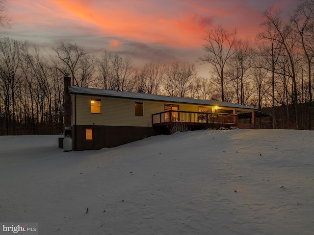 back house at dusk with a wooden deck