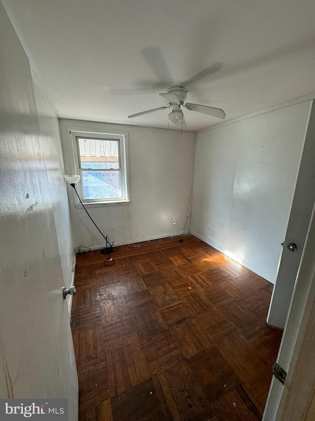 spare room with dark parquet flooring and ceiling fan