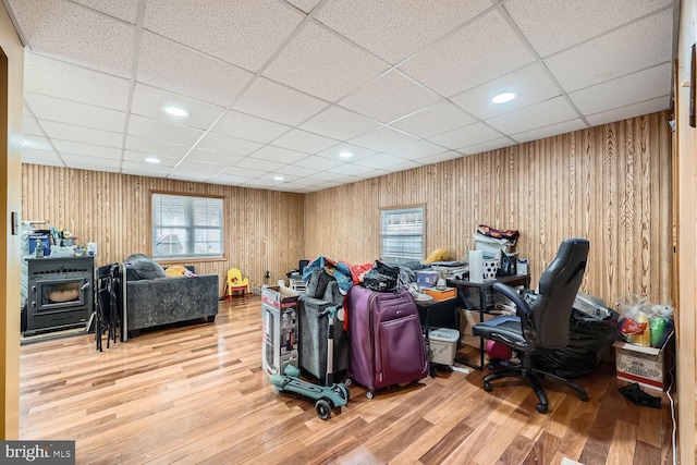 office with a paneled ceiling, wood-type flooring, and wooden walls