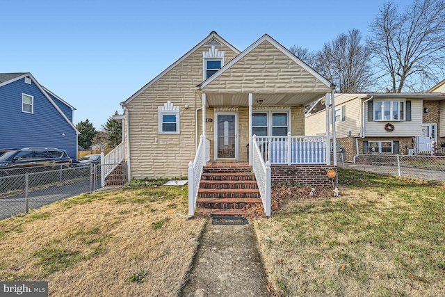 bungalow-style home featuring covered porch and a front yard