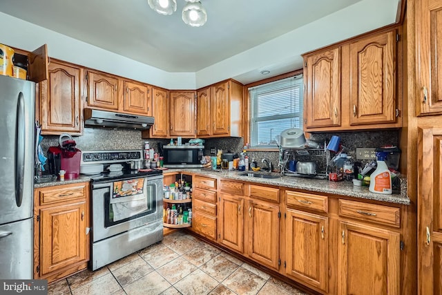 kitchen with decorative backsplash, sink, light stone countertops, and stainless steel appliances