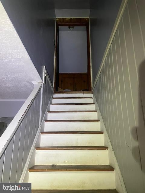 stairway with a textured ceiling