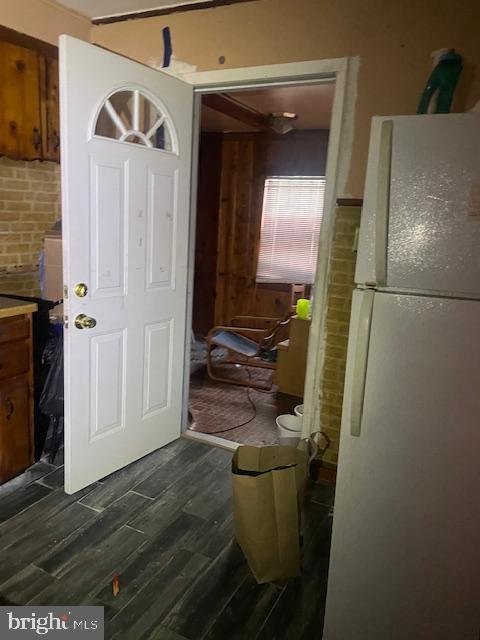 interior space featuring decorative backsplash, white fridge, and dark wood-type flooring