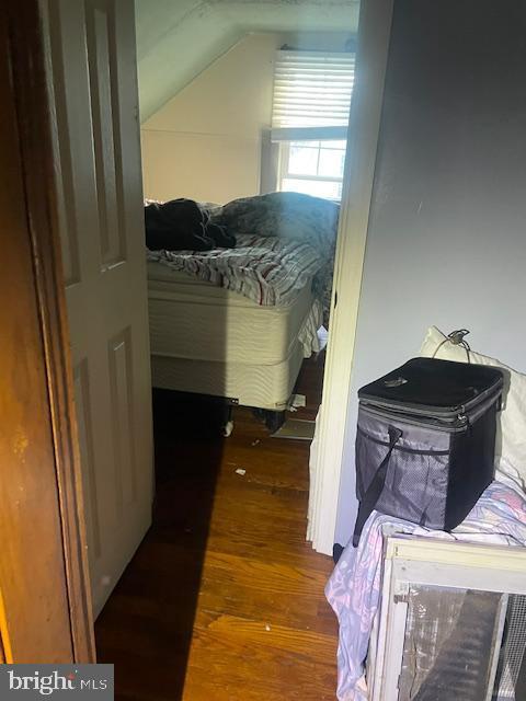 bedroom with dark hardwood / wood-style flooring and lofted ceiling