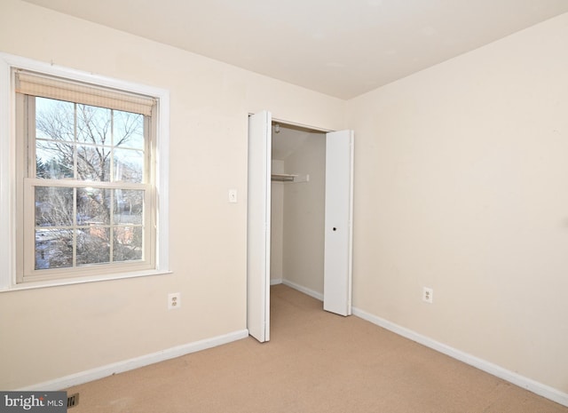 unfurnished bedroom featuring a closet and light carpet