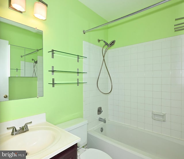 full bathroom featuring toilet, vanity, and tiled shower / bath