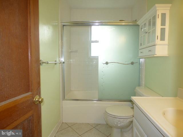 full bathroom with shower / bath combination with glass door, vanity, tile patterned floors, and toilet