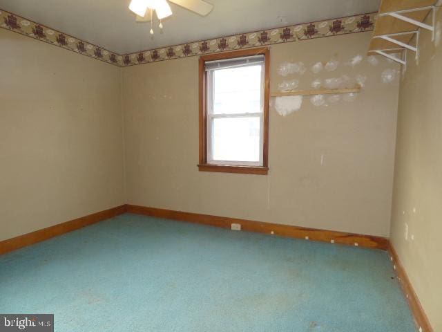 carpeted empty room featuring ceiling fan