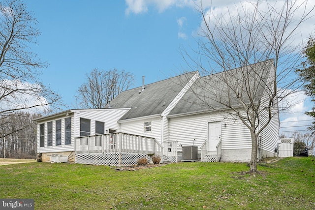 back of property featuring a sunroom, a lawn, cooling unit, and a wooden deck