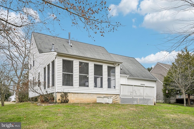 rear view of property with a wooden deck and a yard