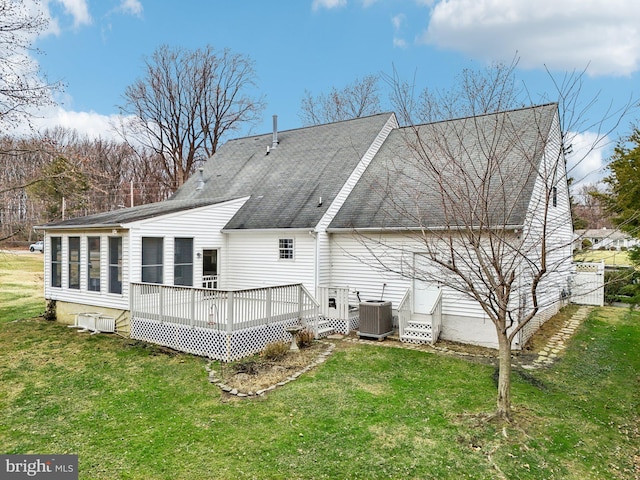 rear view of house featuring a lawn, a wooden deck, and central AC