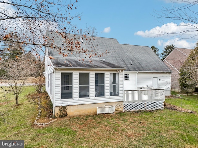 back of house featuring a lawn and a deck