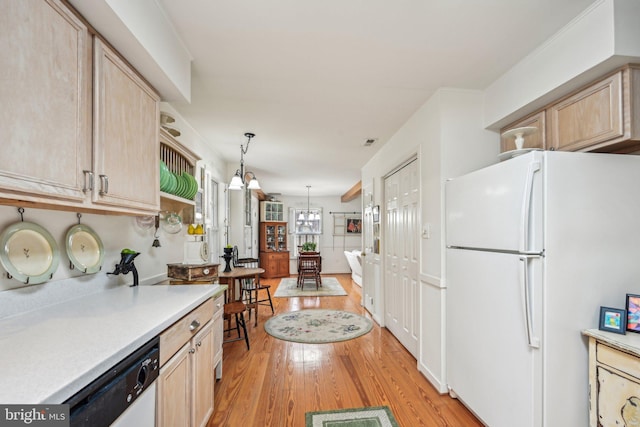 kitchen featuring pendant lighting, light brown cabinets, white appliances, and light hardwood / wood-style flooring