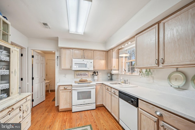 kitchen with light hardwood / wood-style floors, white appliances, sink, and light brown cabinetry