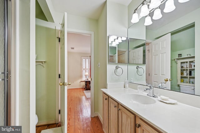 bathroom with vanity, wood-type flooring, and a chandelier