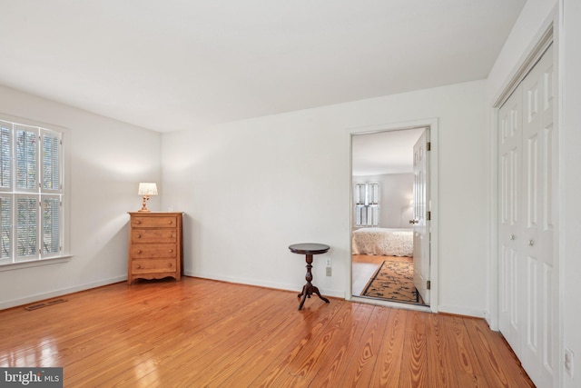 unfurnished bedroom with a closet and light hardwood / wood-style floors