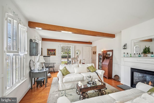 living room with beamed ceiling and light hardwood / wood-style flooring