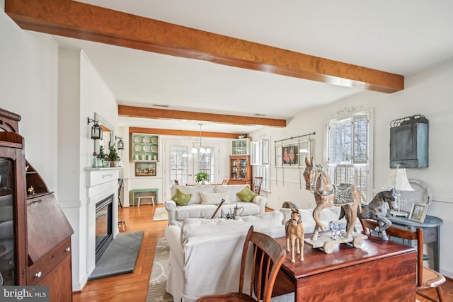 living room featuring beam ceiling and light hardwood / wood-style flooring