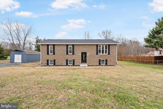 raised ranch with a front yard and a storage shed