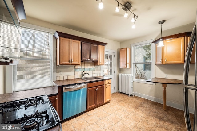 kitchen featuring sink, decorative backsplash, decorative light fixtures, radiator heating unit, and stainless steel appliances