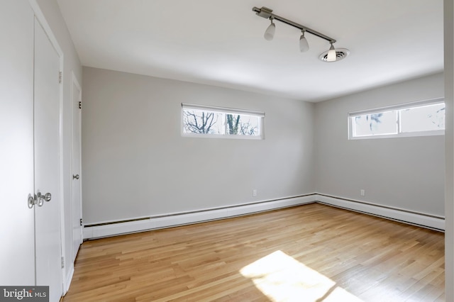 interior space featuring rail lighting, plenty of natural light, and light hardwood / wood-style flooring