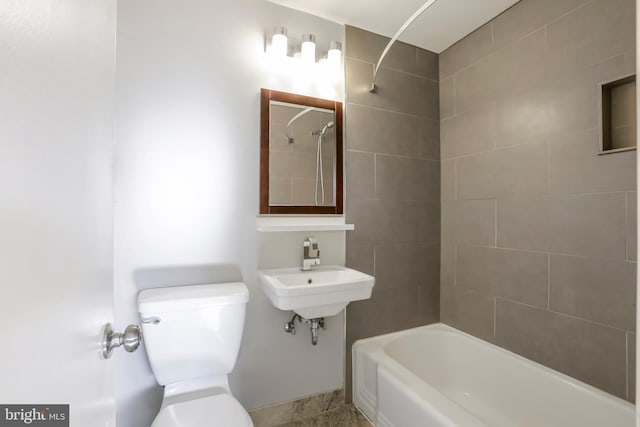 full bathroom featuring tiled shower / bath combo, sink, and toilet