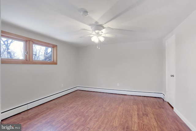 spare room with hardwood / wood-style flooring, ceiling fan, and a baseboard heating unit