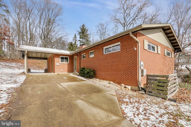 view of snowy exterior featuring a carport