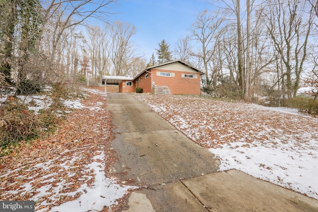 view of snow covered exterior with a carport