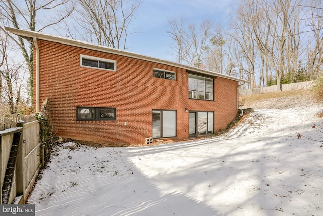 view of snow covered back of property