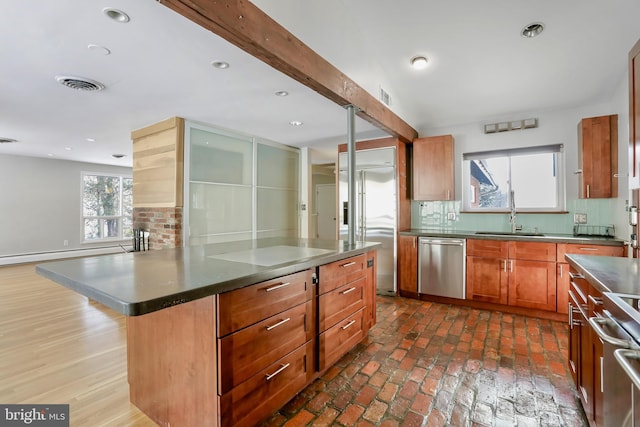 kitchen with sink, beam ceiling, stainless steel appliances, a center island, and decorative backsplash