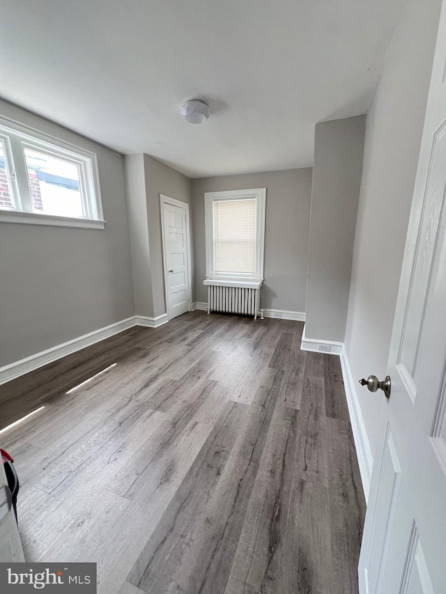 spare room with wood-type flooring and radiator