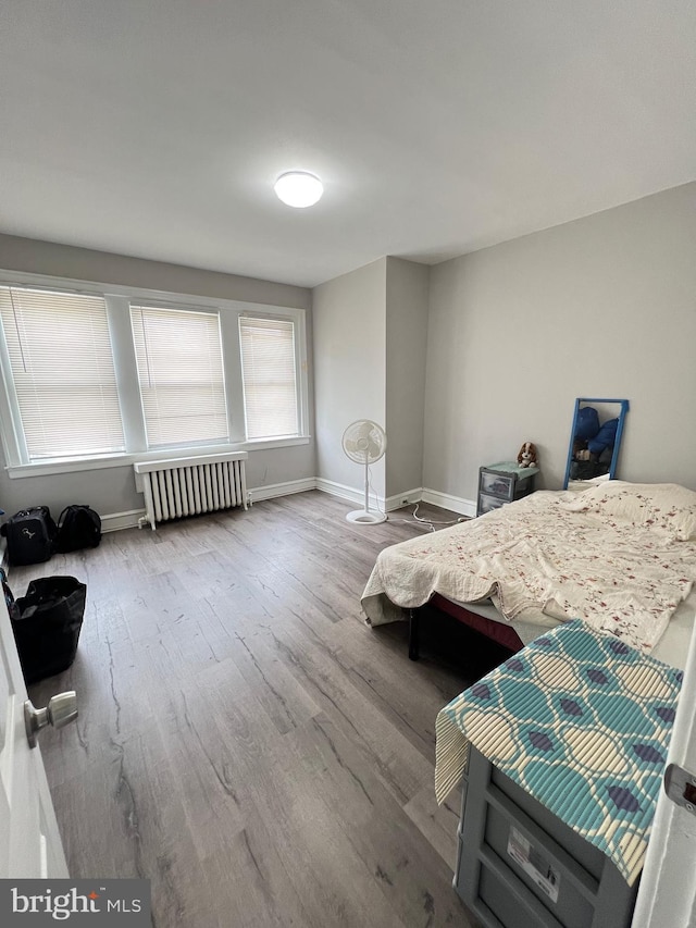 bedroom featuring hardwood / wood-style floors and radiator