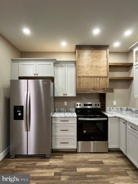 kitchen with white cabinets, wood-type flooring, and appliances with stainless steel finishes