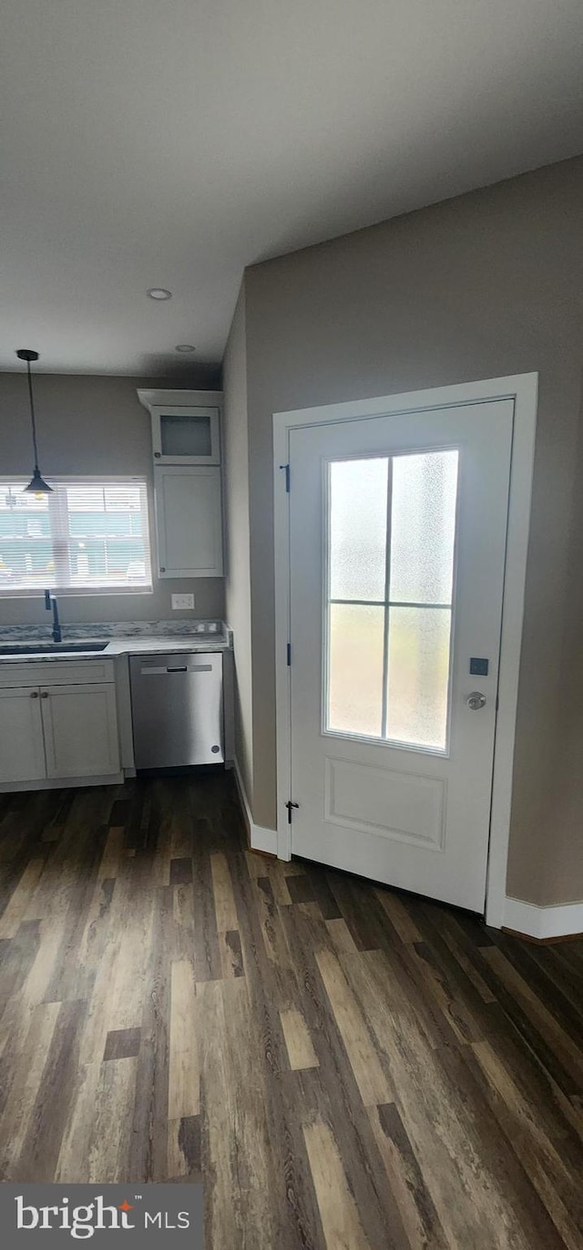 kitchen featuring dishwasher, dark hardwood / wood-style floors, sink, and hanging light fixtures