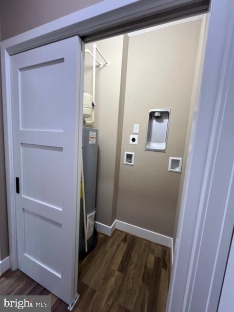 clothes washing area with hookup for an electric dryer, hookup for a washing machine, dark hardwood / wood-style flooring, and gas water heater