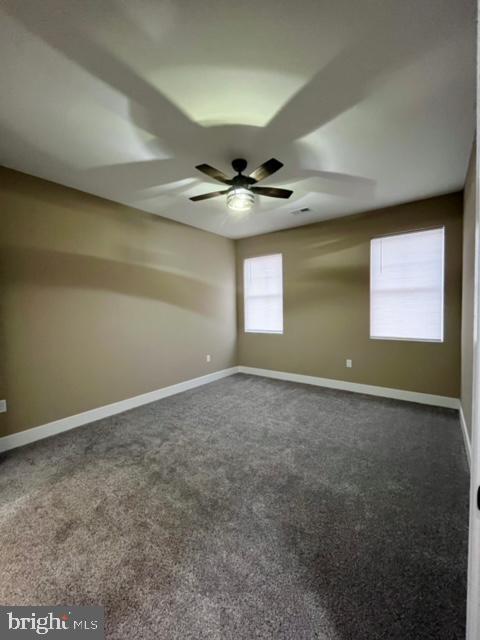 empty room with ceiling fan and carpet floors